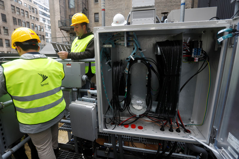 © Reuters. Sprint technicians work on the installation 5G technology next to fiber cables on top of a building in New York City