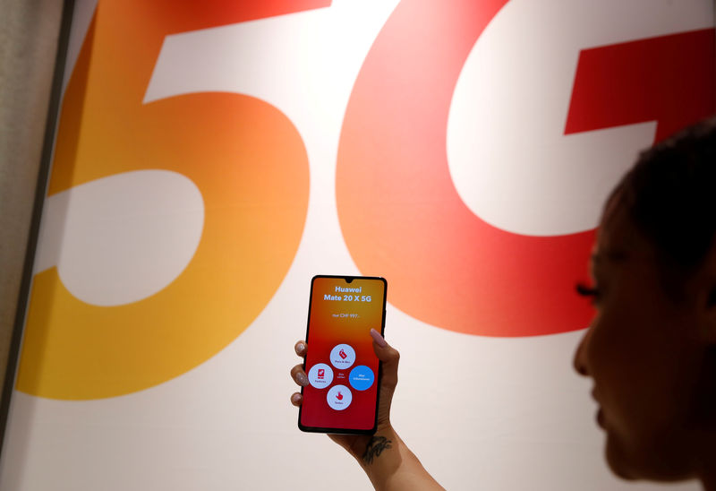 © Reuters. FILE PHOTO: An employee displays a Huawei 5G Smartphone Mate 20X smartphone at a Sunrise telecommunications shop in Opfikon