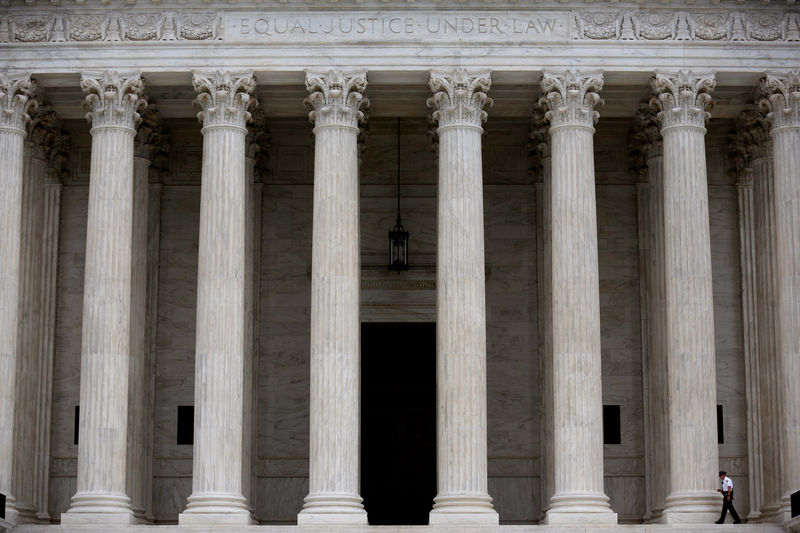 © Reuters. FILE PHOTO: A police officer walks by columns at the Supreme Court in Washington
