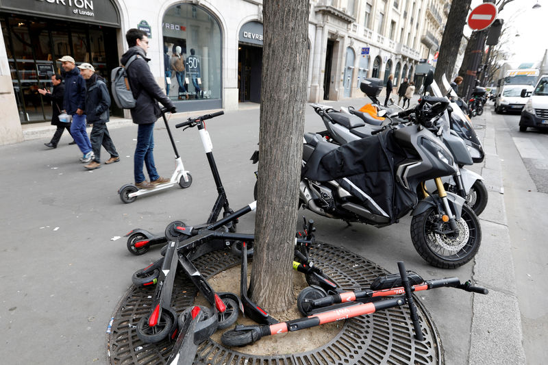 © Reuters. FILE PHOTO: A man rides aN electric scooter on the sidewalk in Paris