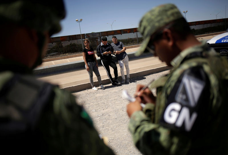 © Reuters. FILE PHOTO: Members of Mexico's National Guard detain Cuban migrants after they were trying to cross illegally the border between the U.S. and Mexico, in Ciudad Juarez