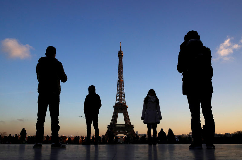 © Reuters. People stand at the Trocadero square near the Eiffel Tower in Paris