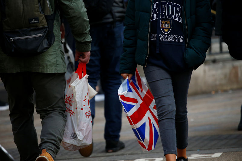© Reuters. FILE PHOTO: Shoppers carry shopping in plastic bags in the West End, in London