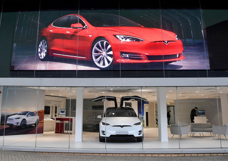 © Reuters. FILE PHOTO: Employees work in a Tesla showroom in west London, Britain