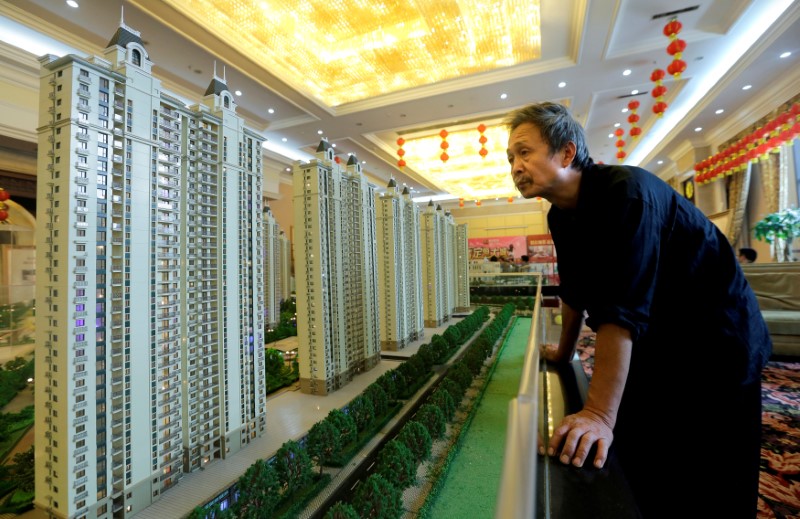 © Reuters. A visitor looks at a model of a new apartment complex in Wuhan