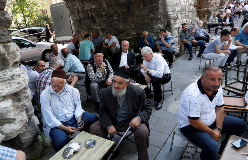 © Reuters. Men sit at an open-air cafe in Istanbul