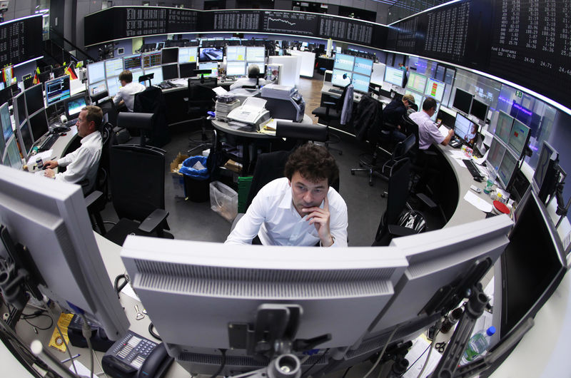 © Reuters. Traders work at their desks in front of DAX board at the Frankfurt Stock Exchange