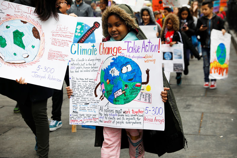 © Reuters. Students hold banners and placards during a demonstration against climate change in New York