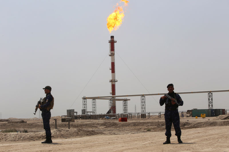 © Reuters. FILE PHOTO: Members of the oil police guard near the West Qurna-1 oilfield, which is operated by ExxonMobil, near Basra