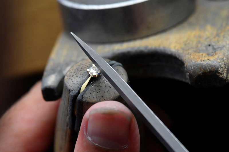 © Reuters. A craftsperson shapes the jewel clasp of a diamond ring at the jewellery workshop of 77 Diamonds in London