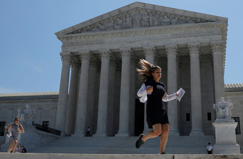 © Reuters. News assistants run outside the U.S. Supreme Court in Washington