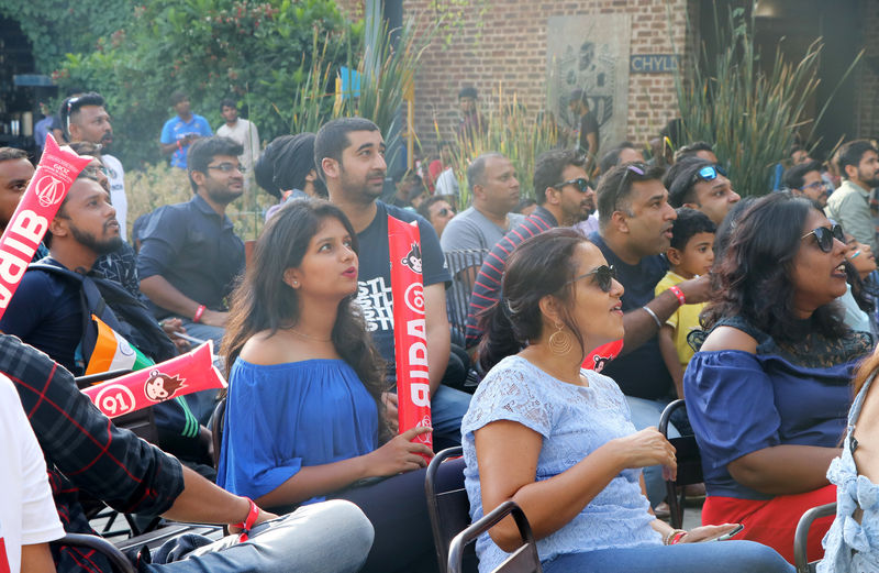 © Reuters. Fans watch ICC cricket world cup match between India and Pakistan, on a screen at a brewery in Bengaluru