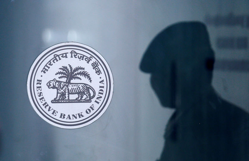 © Reuters. A security guard's reflection is seen next to the logo of the Reserve Bank Of India (RBI) at the RBI headquarters in Mumbai