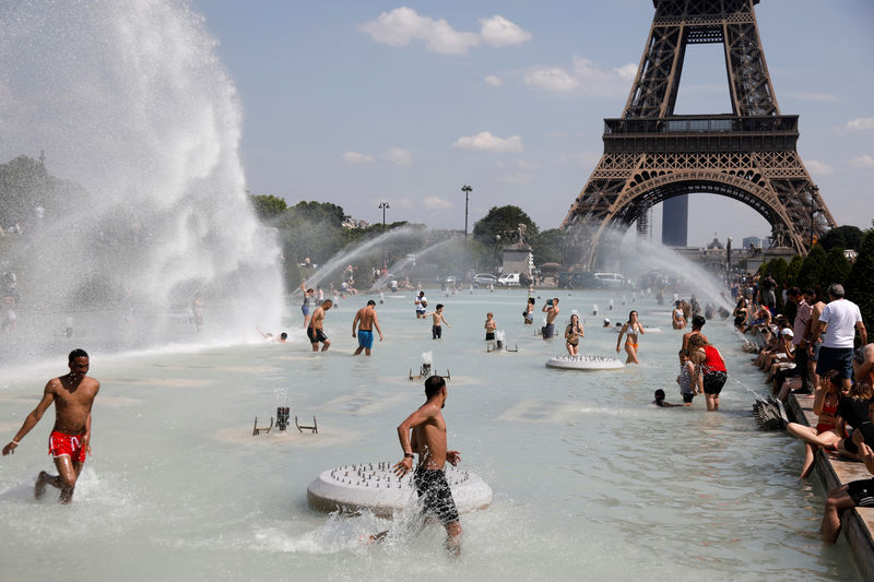 © Reuters. La gente se refresca en las fuentes de Trocadero frente a la Torre Eiffel, en París, Francia