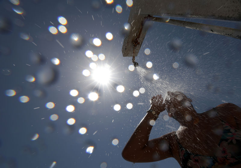 © Reuters. Mulher se refresca em chuveiro em praia de Nice em mais um dia de forte calor na França