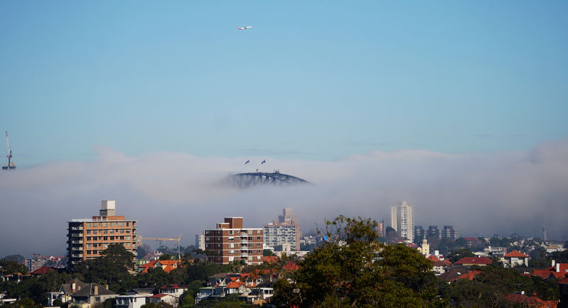 © Reuters. A Qantas plane flies over Sydney on a foggy day