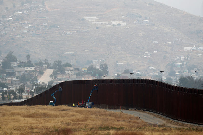 © Reuters. Workers weld sections of a newly replaced border wall with Tijuana, Mexico near the the Otay Mesa border crossing in San Diego, California