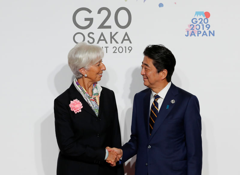 © Reuters. International Monetary Fund (IMF) Managing Director Christine Lagarde is welcomed by Japanese Prime Minister Shinzo Abe upon her arrival for a welcome and family photo session at G20 leaders summit in Osaka