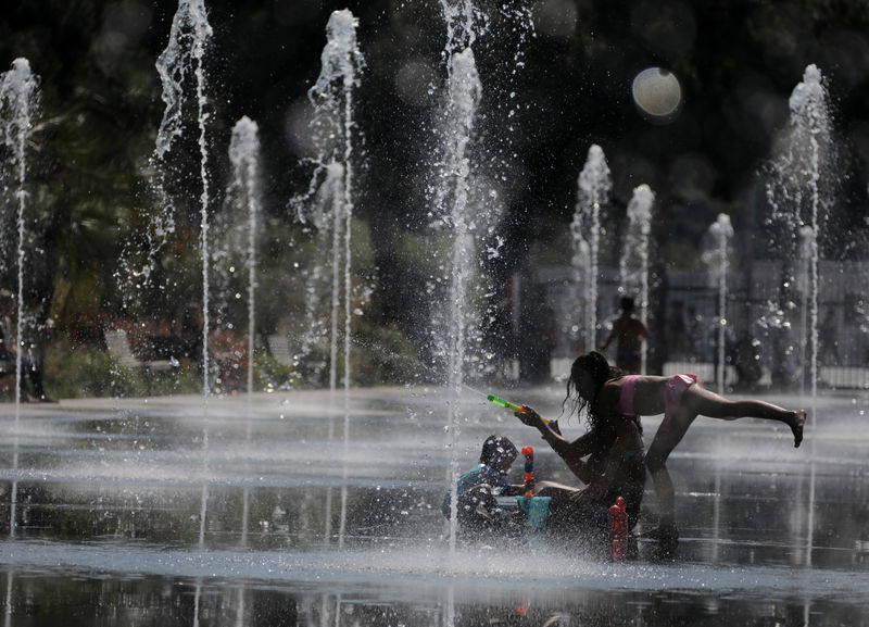 © Reuters. People cool off in a fountain in Nice as a heatwave hits much of the country