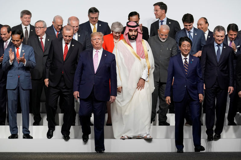 © Reuters. Los líderes del G20 descienden de un estrado tras tomarse una foto de familia durante una cumbre en Osaka, en Japón.