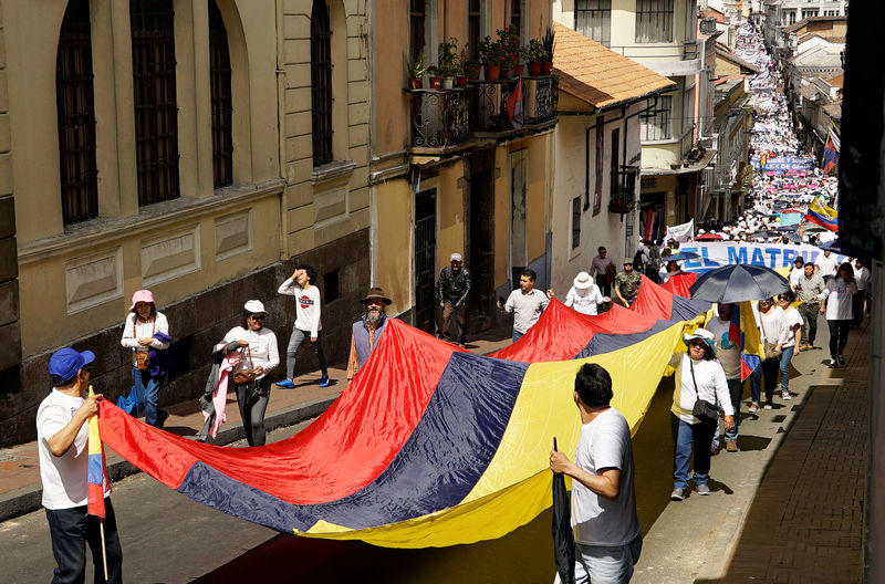 © Reuters. Gente porta una enorme bandera de Ecuador mientras protesta contra el aborto y los derechos de la comunidad LGBTQ, después de una decisión judicial que legalizó el matrimonio civil entre parejas del mismo sexo, en Quito