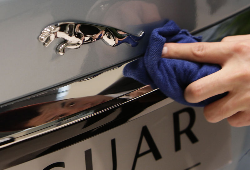 © Reuters. An employee cleans the logo of a Jaguar XJ car at a dealership in Beijing