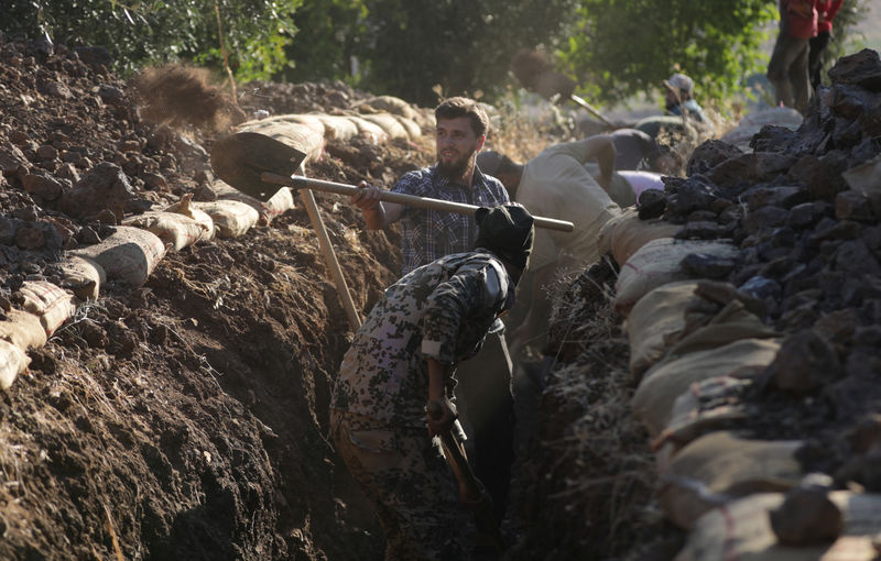 © Reuters. متطوعون سوريون يحفرون الخنادق ويطهون الطعام في الحرب مع الأسد