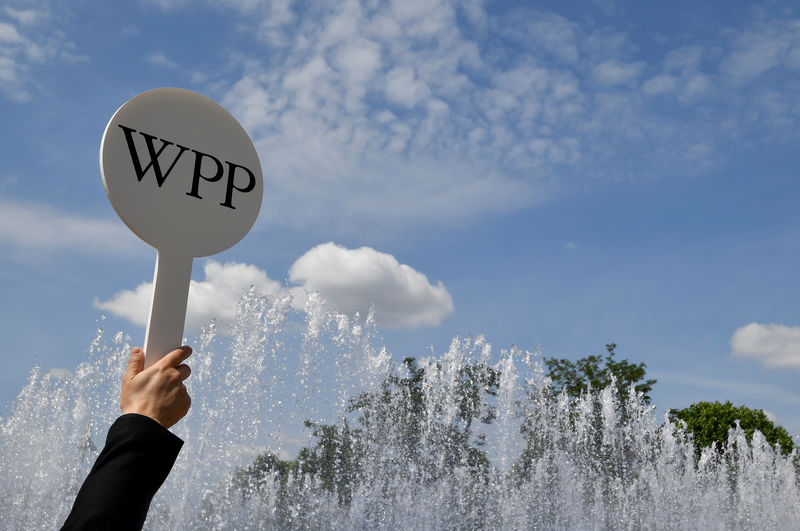 © Reuters. FILE PHOTO: An usher holds a baton to guide attendees towards the AGM of advertising agency WPP in London, Britain