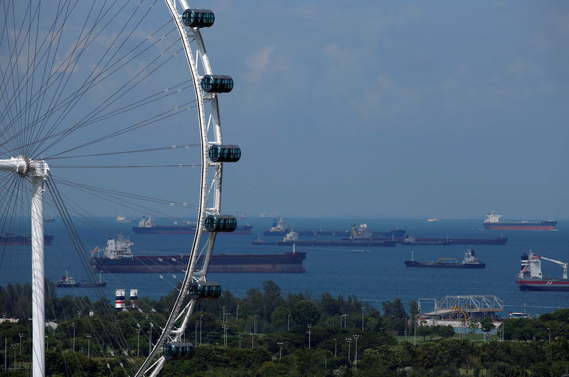 © Reuters. Tankers line the anchorage area behind the Singapore Flyer observatory wheel in Singapore