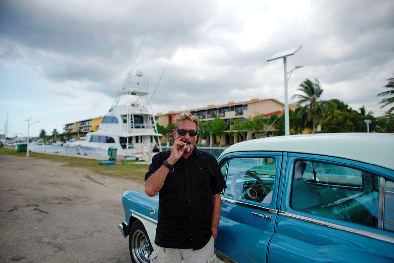 © Reuters. John McAfee smokes a cigarette before taking a taxi at the Marina Hemingway in Havana