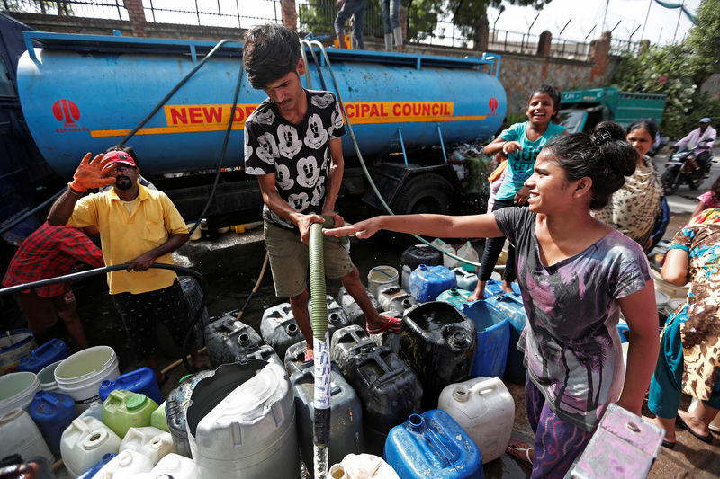 © Reuters. Residents fill their containers with drinking water from a municipal tanker in New Delhi