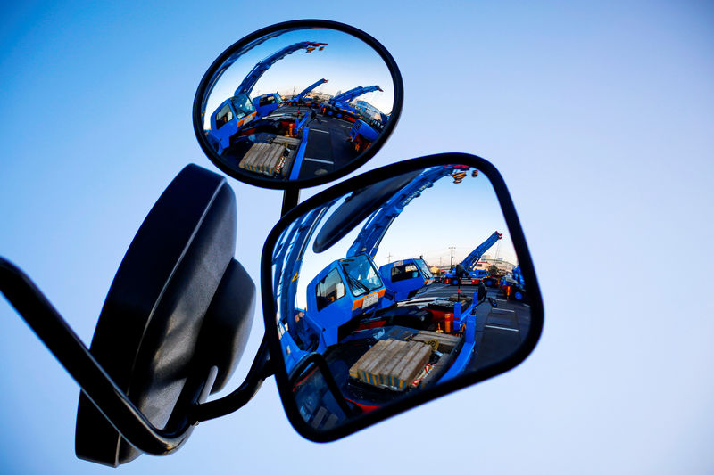 © Reuters. FILE PHOTO: Construction cranes are reflected in mirrors at company compound in Tokyo