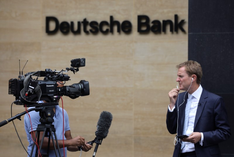 © Reuters. Media members are pictured near a Deutsche Bank office in London