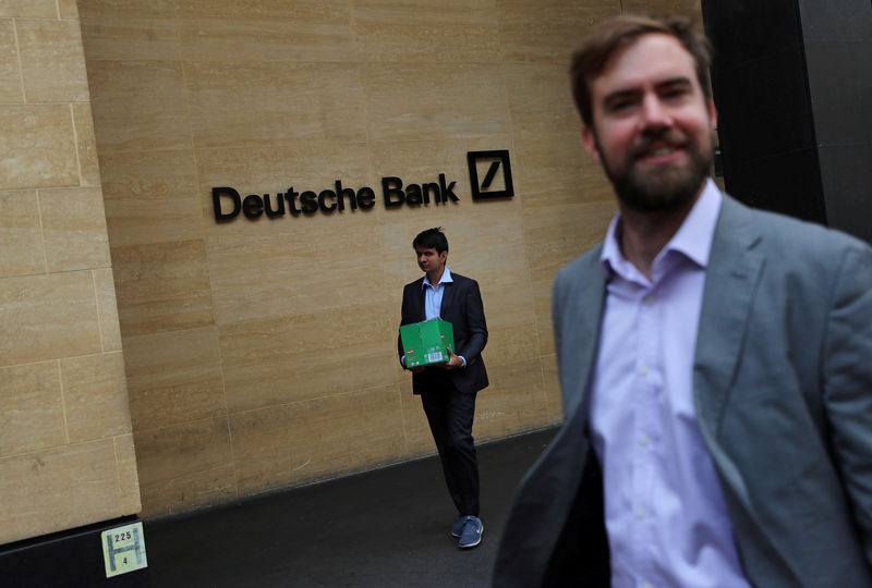 © Reuters. A man carrying a box leaves a Deutsche Bank office in London