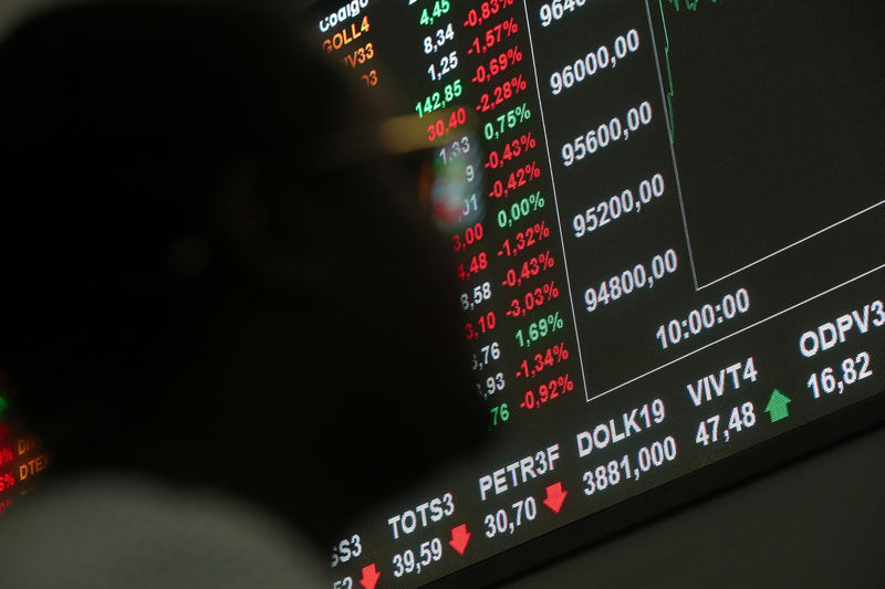 © Reuters. Uma mulher olha para uma placa eletrônica mostrando as recentes flutuações dos índices de mercado no pregão da bolsa paulista B3