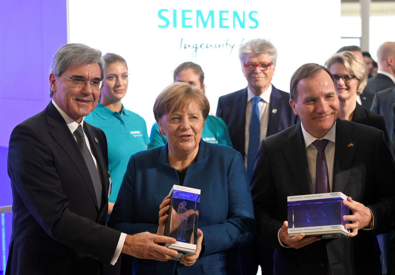 © Reuters. German Chancellor Angela Merkel and Swedish Prime Minister Stefan Lofven take part in the opening walk of the Hanover trade fair, in Hanover,