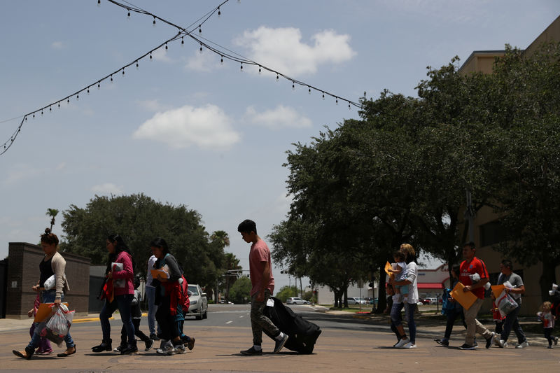 © Reuters. FILE PHOTO: Undocumented immigrant families walk from a bus depot to a respite center after being released from detention in McAllen