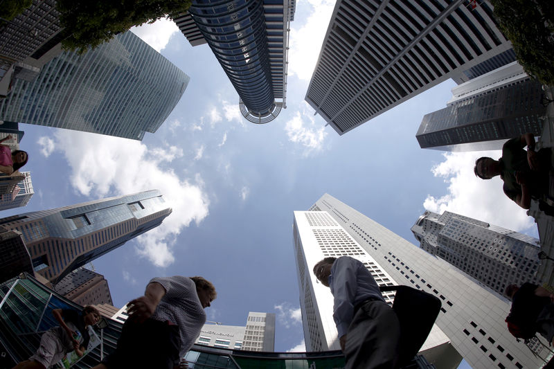 © Reuters. FILE PHOTO: People walking past office buildings at the central business district in Singapore