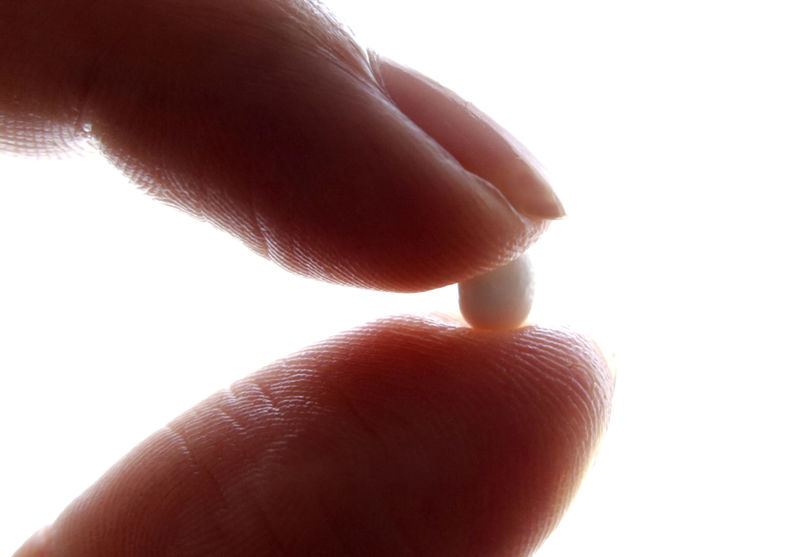 © Reuters. FILE PHOTO: An illustration picture shows a woman holding a pill at her home in Nice