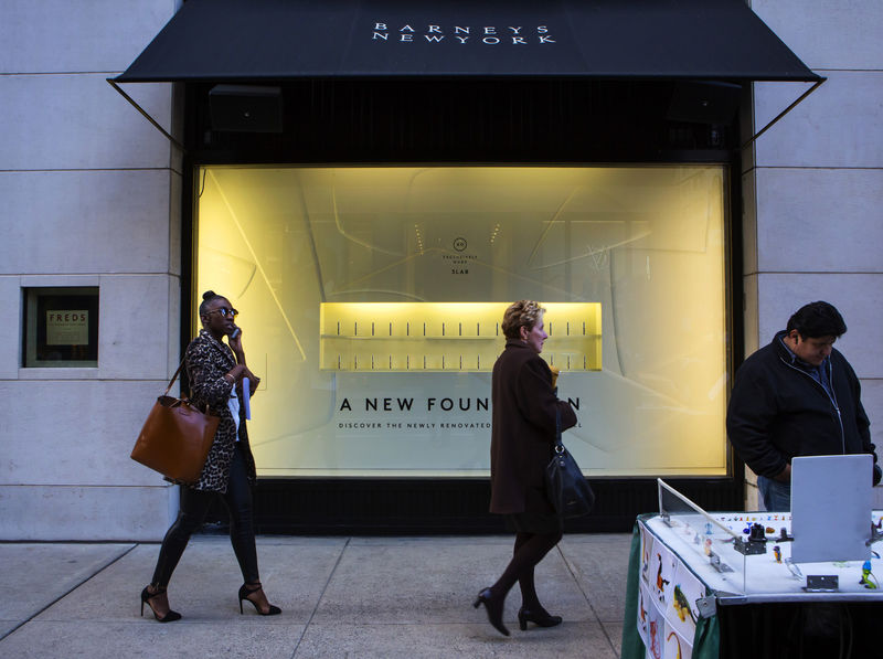 © Reuters. FILE PHOTO - People walk by a Barneys New York retail store in New York