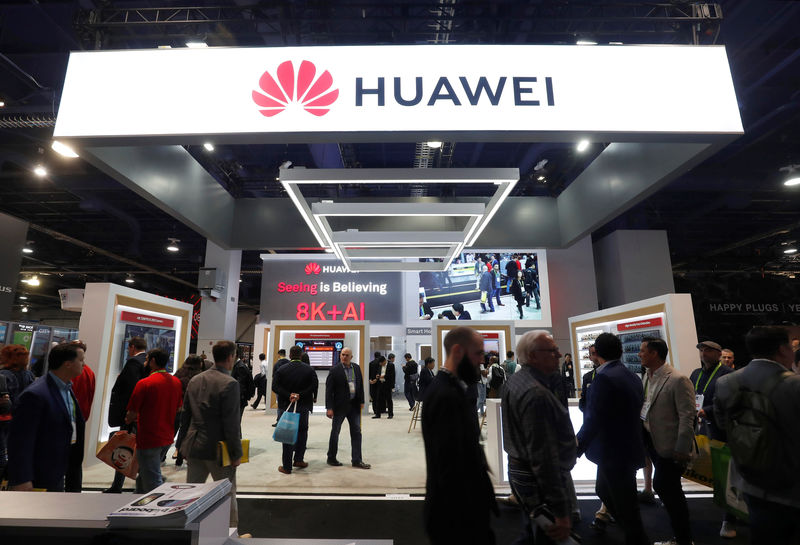© Reuters. Attendees pass by a Huawei booth during the 2019 CES in Las Vegas