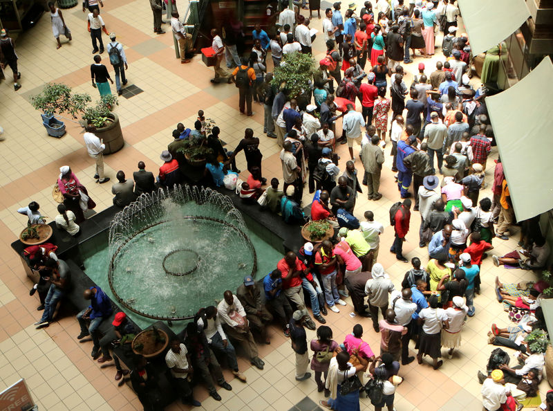 © Reuters. FILE PHOTO: People queue to withdraw money from a bank in Harare