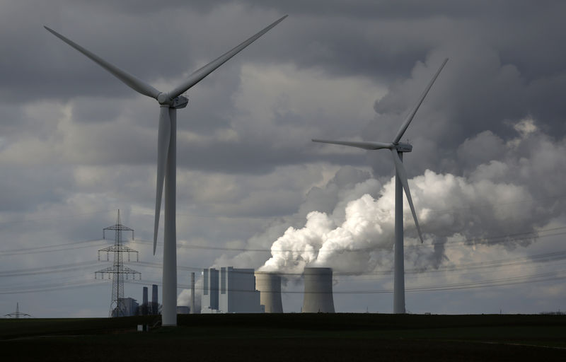 © Reuters. Wind turbines are seen in front of a coal power plant of German utility RWE Power near the western town of Neurath