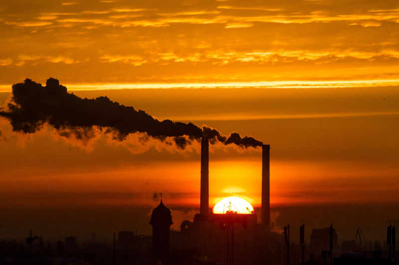 © Reuters. Sun rises behind billowing chimneys of power station in Berlin