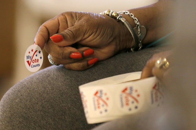 © Reuters. FILE PHOTO: FILE PHOTO: A worker holds stickers for voters at a polling station at the Princeton Baptist Church during the U.S. presidential election, in Princeton, North Carolina