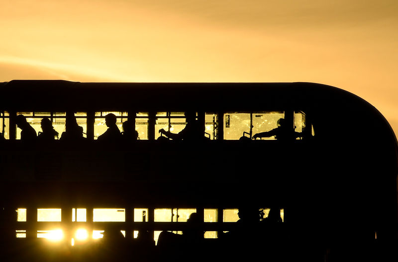 © Reuters. FILE PHOTO: Workers are seen crossing London Bridge in a bus at sunrise in London