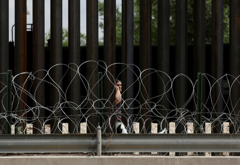 © Reuters. Migrant woman is seen through the border fence after crossing illegally into El Paso, Texas, U.S., as seen from Ciudad Juarez