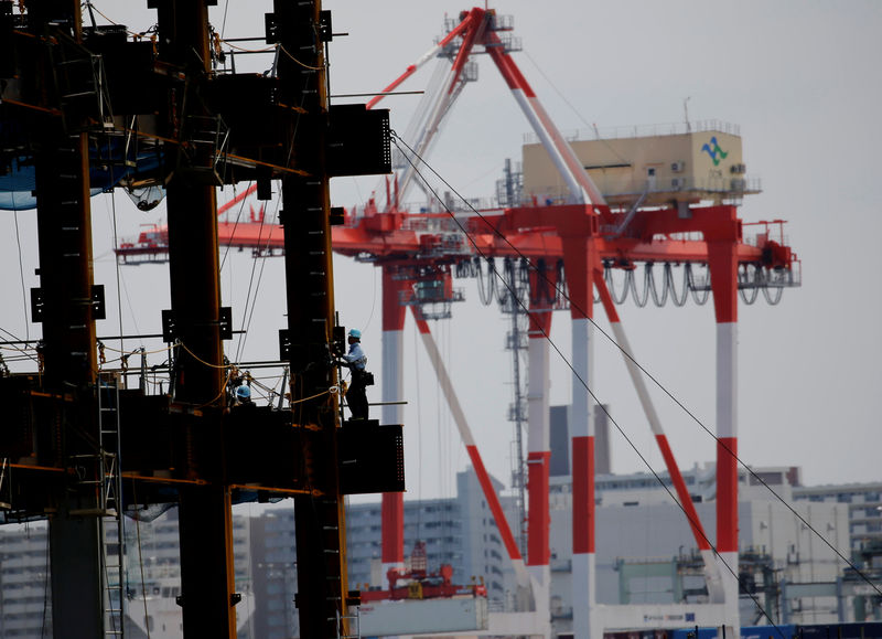 © Reuters. A man works in a construction site at an industrial port in Tokyo