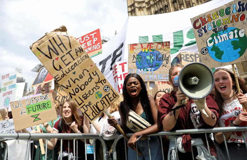 © Reuters. FILE PHOTO: Climate change demonstrators hold placards during a march supported by Extinction Rebellion outside the Houses of Parliament in London