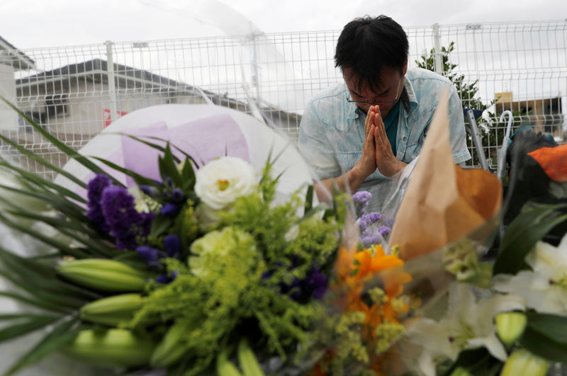 © Reuters. عشاق الرسوم المتحركة يضعون الزهور في موقع هجوم كيوتو اليابانية